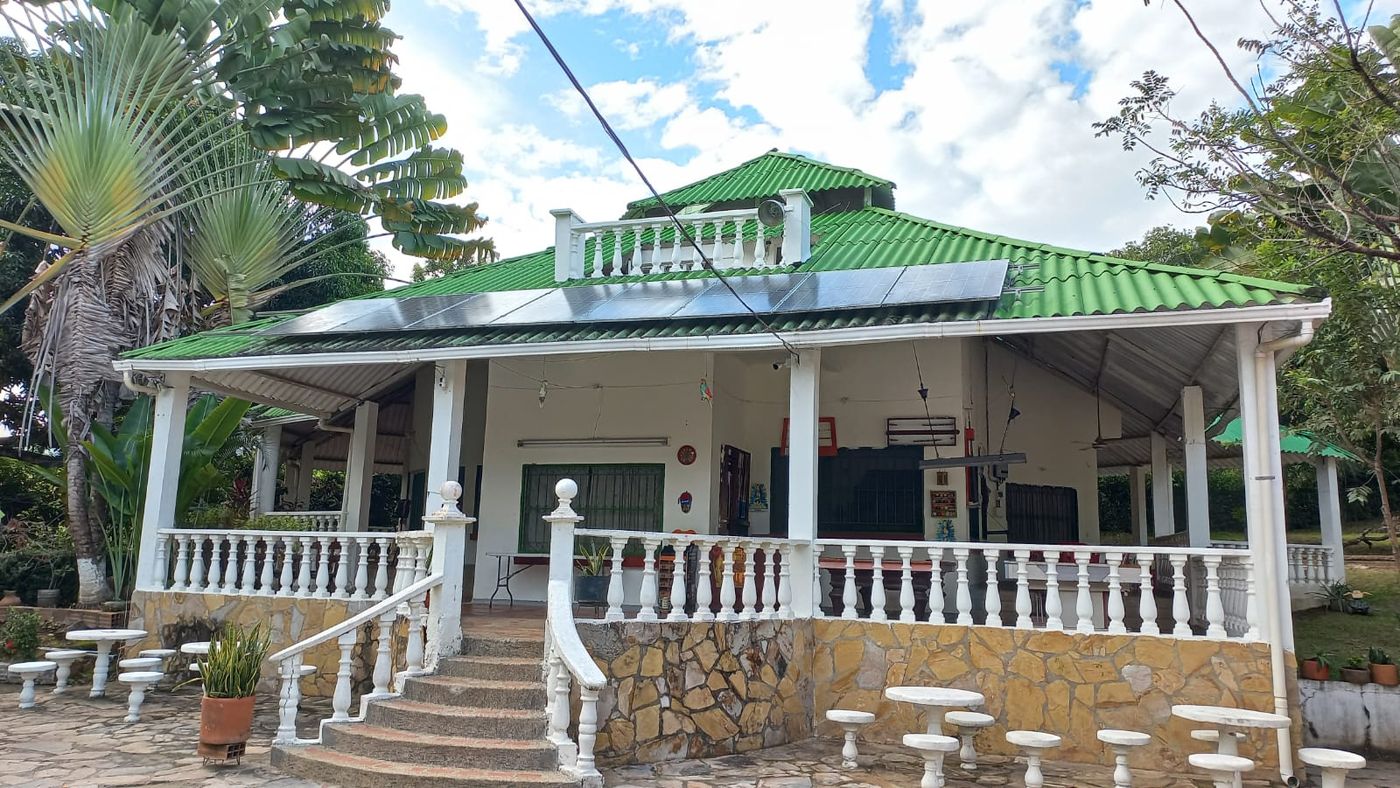 Casa de una finca recreativa con una fila de paneles solares sobre la cubierta de teja verde